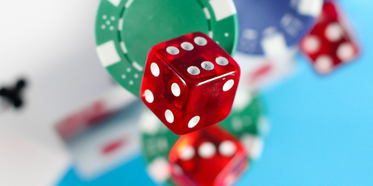 Glimpse of red dice flanked by slightly blurred poker chips.