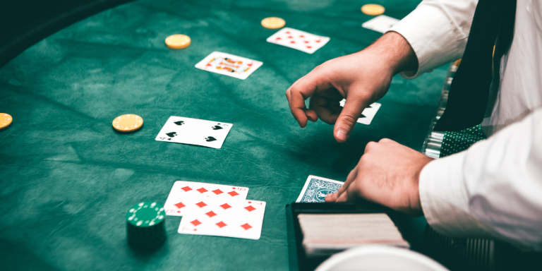 A dealer distributing poker cards across the casino table.