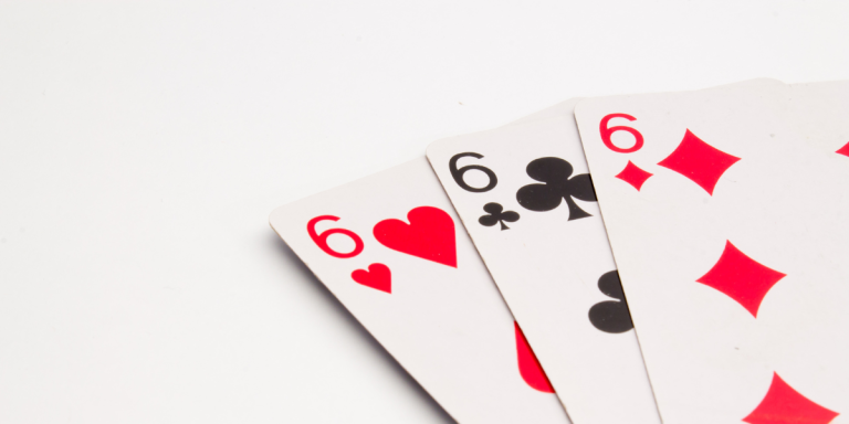 Three playing cards displaying the number six with various suits